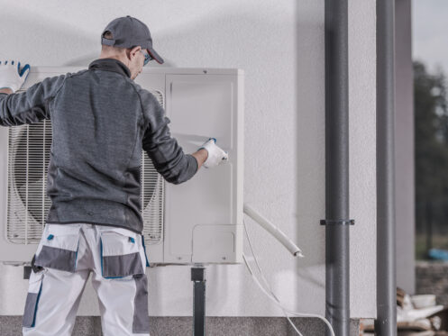 HVAC technician installing electric heat pump